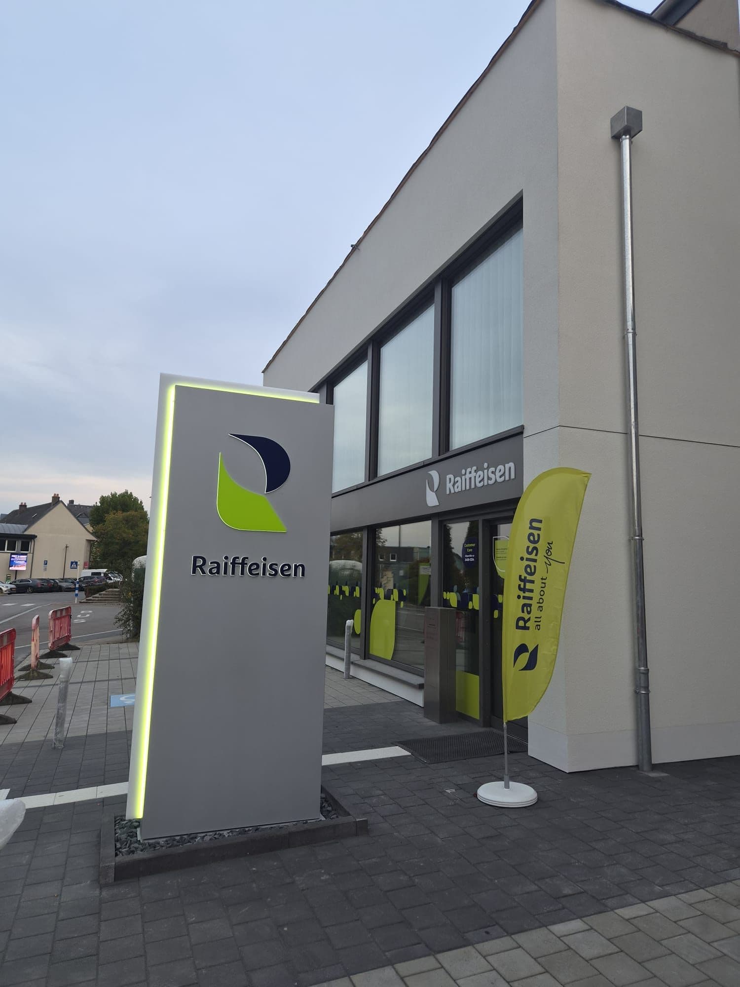 Totem lumineux Raiffeisen devant l'agence